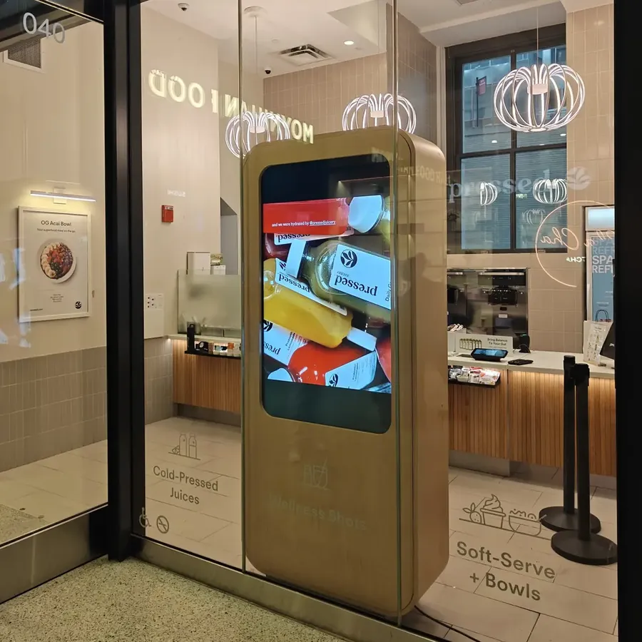 Digital signage kiosk in a birch enclosure at Pressed Juicery, Moynihan Train Hall, Penn Station